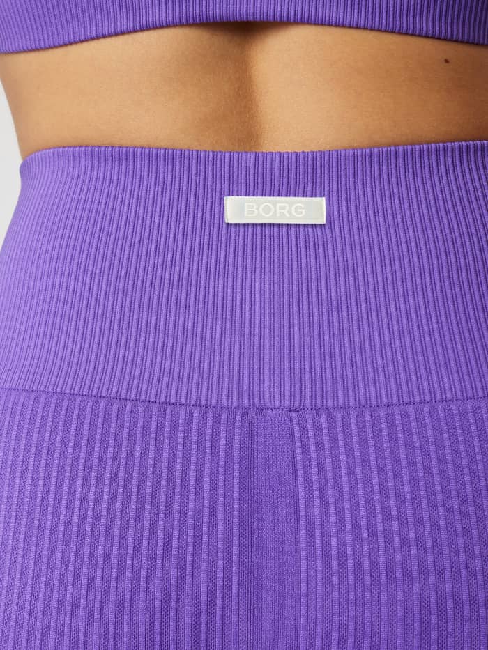 Nahaufnahme der Studio Seamless Ribbed Tights in Simply Purple (Lila) mit weißem Logo und Trainingspassform. - Image 3
