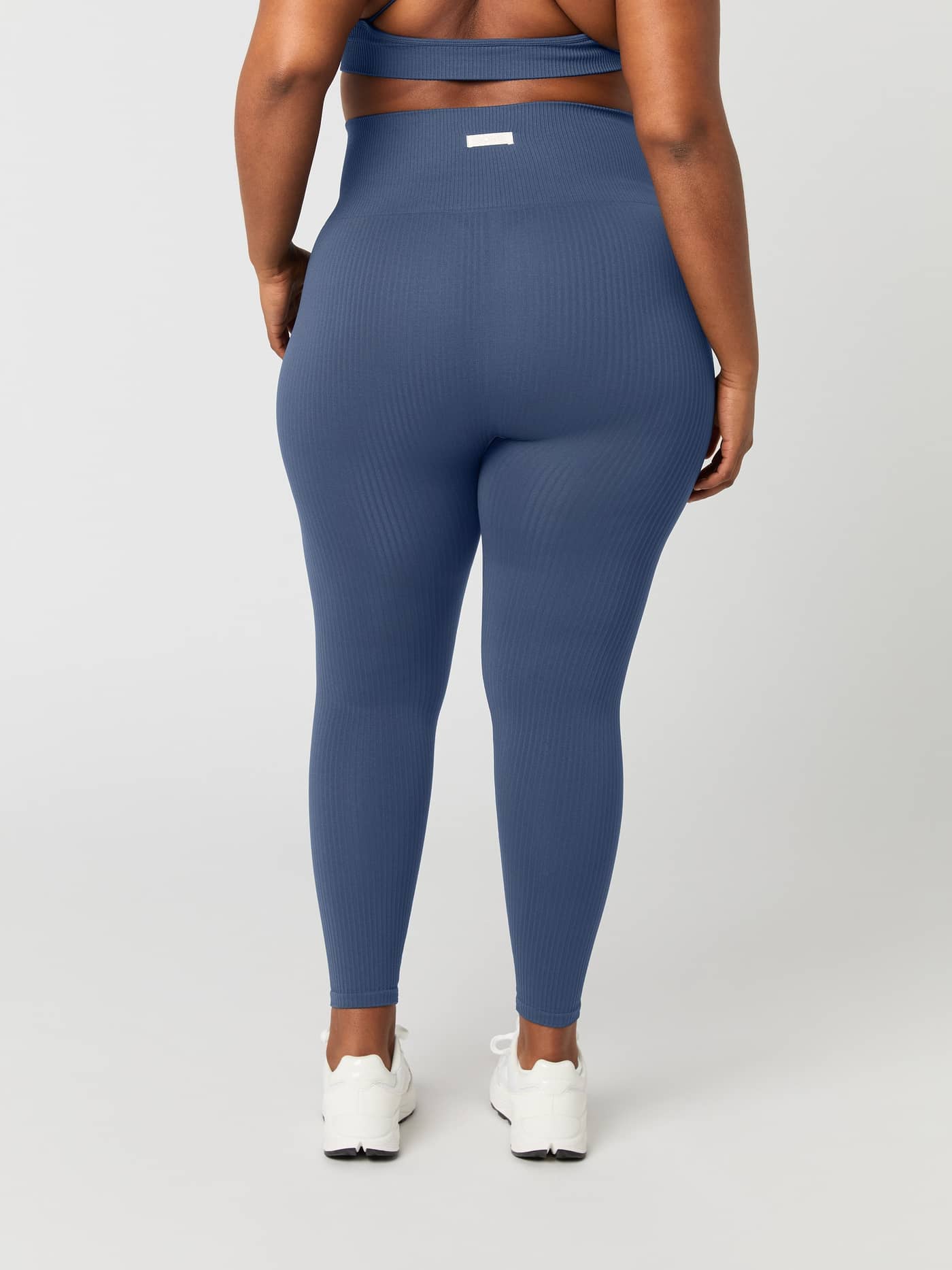 Back view of a woman wearing the Björn Borg Studio Seamless Ribbed Tights in Nightshadow Blue. - Image 5