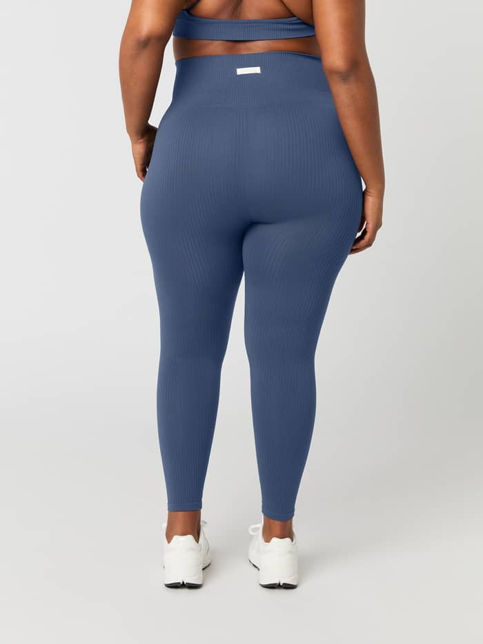 Back view of a woman wearing the Björn Borg Studio Seamless Ribbed Tights in Nightshadow Blue.