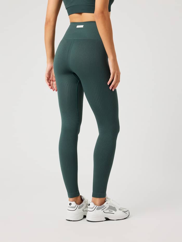 Rückansicht eines Models in Studio Seamless Ribbed Tights in Urban Chic (Grün) für Training mit weißem Logo-Label. - Image 3