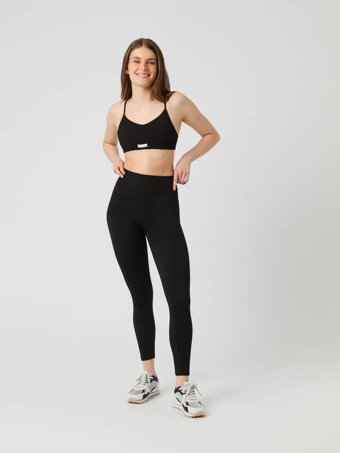 Studio Seamless Ribbed Strap Bra i Svart för dam sedd framifrån i helfigur med vit logo och snygg passform. - Image 3