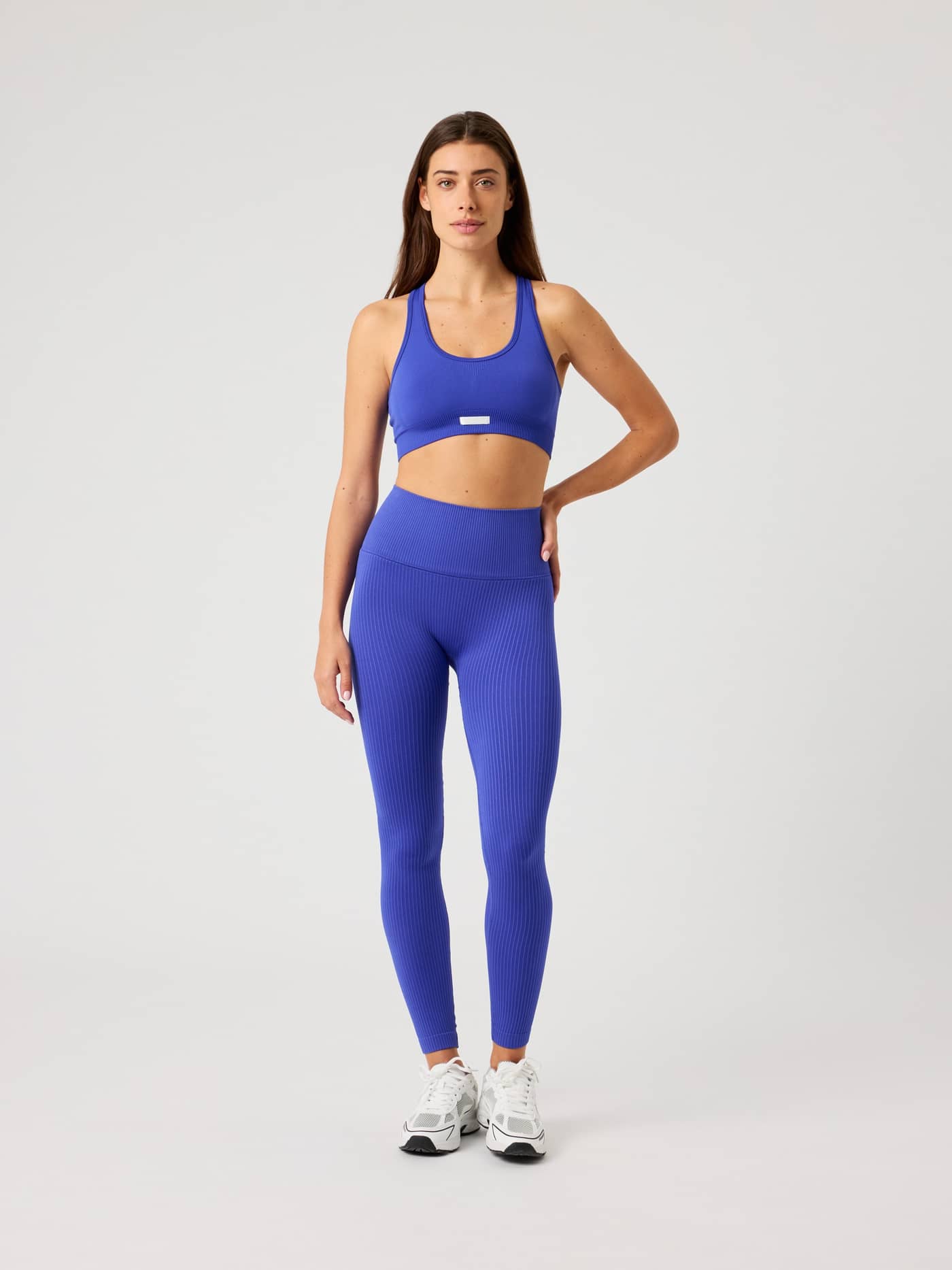 Full-body front view of a woman wearing the Björn Borg Studio Seamless Low Sports Bra in Blue for training. - Image 4