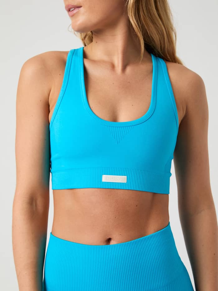 Närbild framifrån på Studio Seamless Low Sports Bra i Atomic Blue (Blå) för träning med sömlös design och vit logotyp. - Image 4