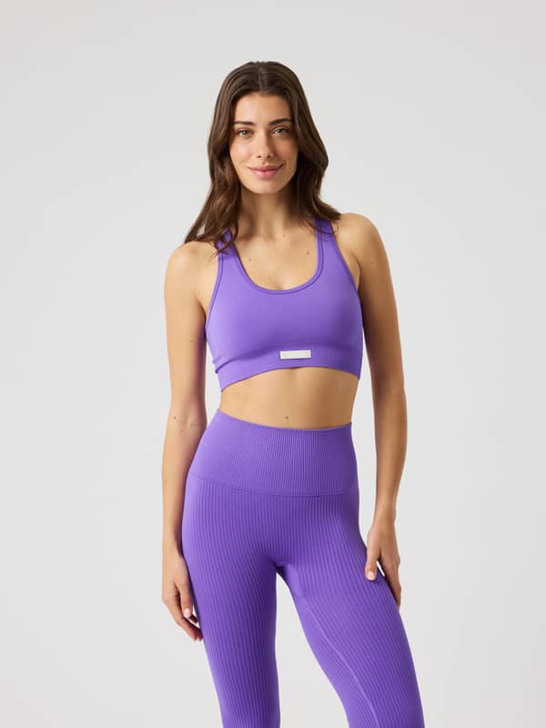 Modell framifrån i Studio Seamless Low Sports Bra i Simply Purple (Lila) med en stilren passform för träning.