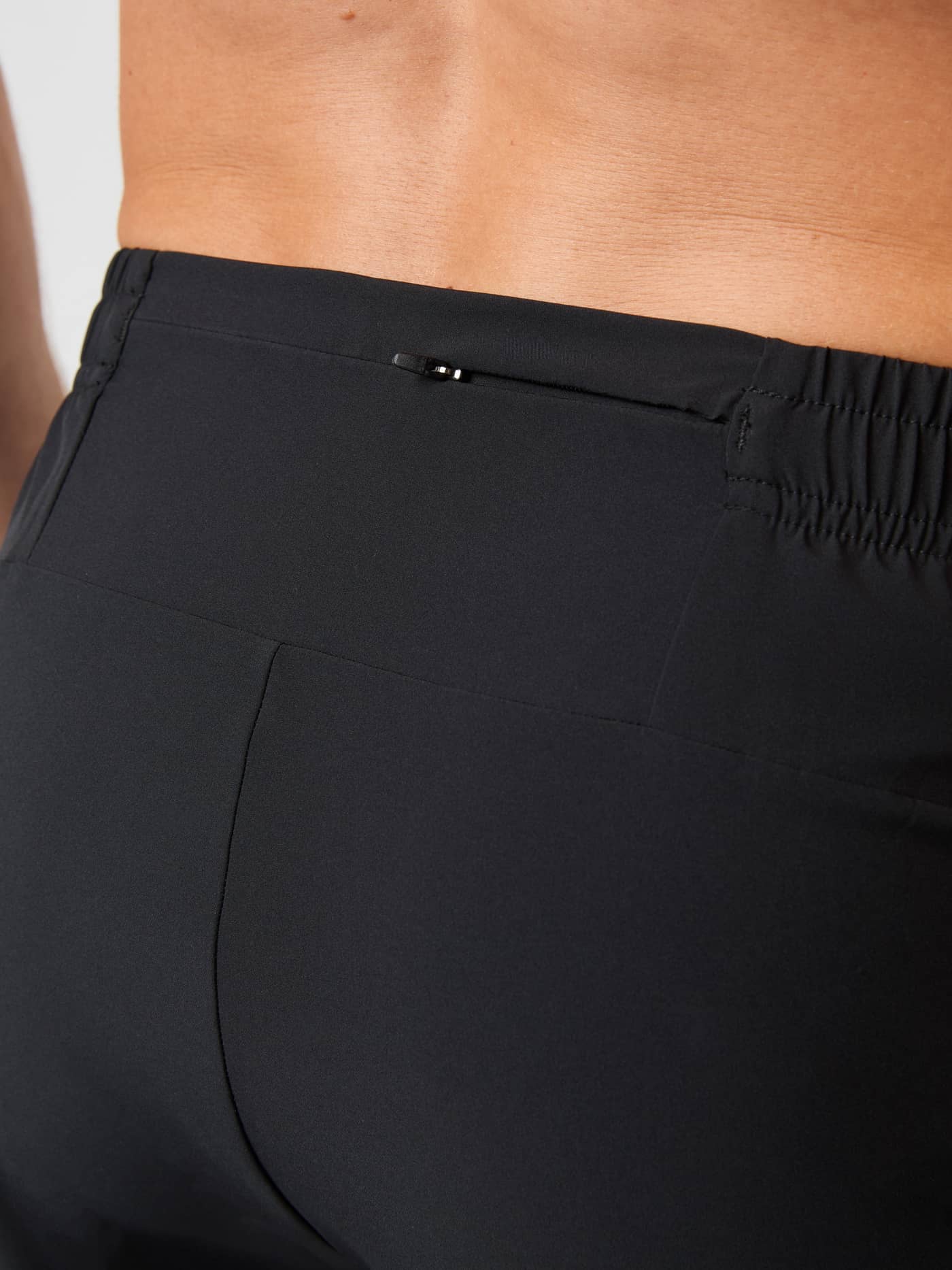 Detailed close-up of the Borg Running Pants in Black Beauty (Black), showcasing the functional zippered back pocket. - Image 4