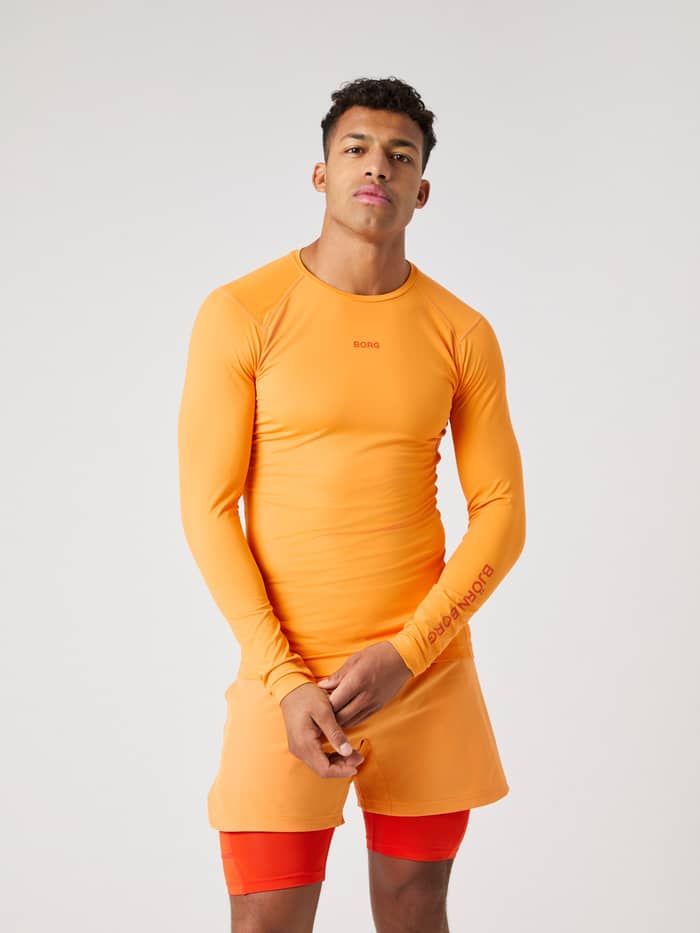 Front view of a man wearing the Borg Soft Compression Ls T-Shirt in Sun Orange (Orange) for training.