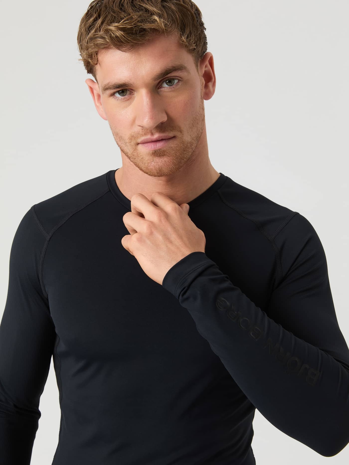 Front close-up of a man in the Borg Soft Compression Ls T-Shirt in Black Beauty (Black) with a tonal logo for training. - Image 3