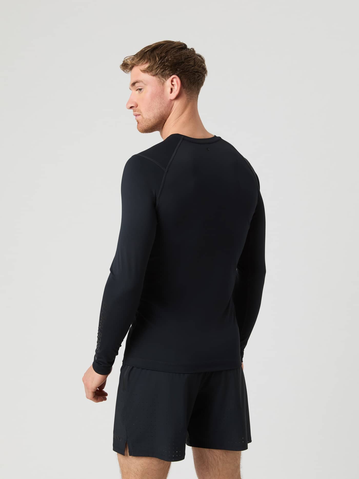 Back view of a man wearing the slim fit Borg Soft Compression Ls T-Shirt in Black Beauty (Black) for training. - Image 2