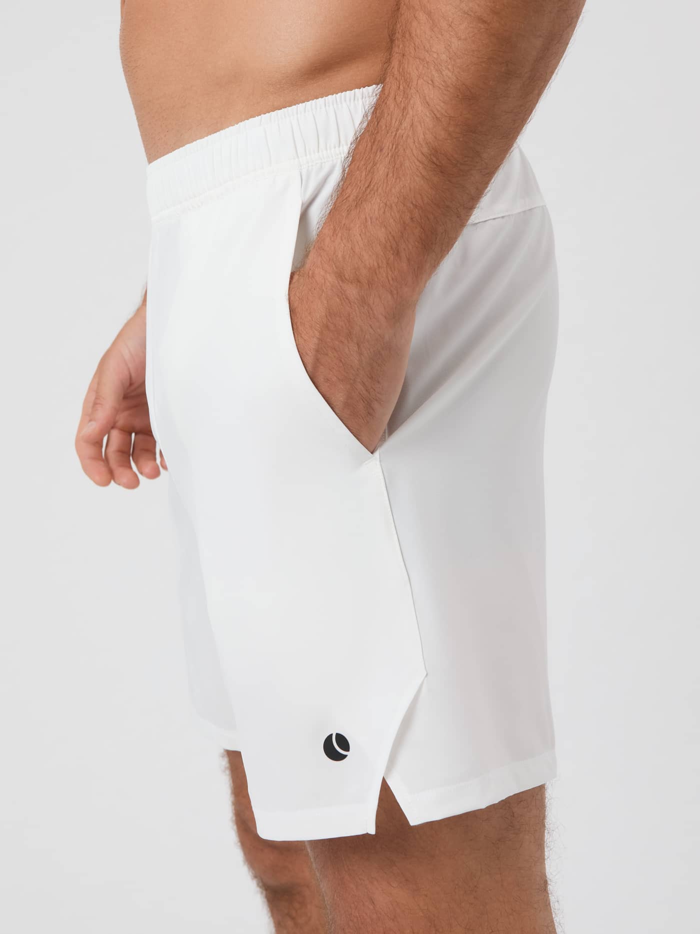 Ace Racquet Shorts 7 inch i Brilliant White (Hvid) set fra siden med sort logo og hånd i lommen til tennis. - Image 6