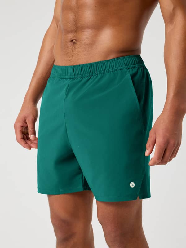 Vue de face d'un homme en Ace Racquet Shorts 7 Inch en Posy Green (Vert) en polyester recyclé avec logo blanc pour le tennis.