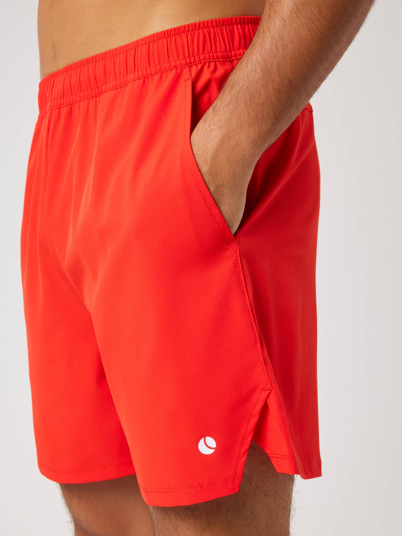 Side detail of the Ace Racquet Shorts 7 Inch in Flame Scarlet (Red) for tennis, with side slits and a white logo. - Image 4
