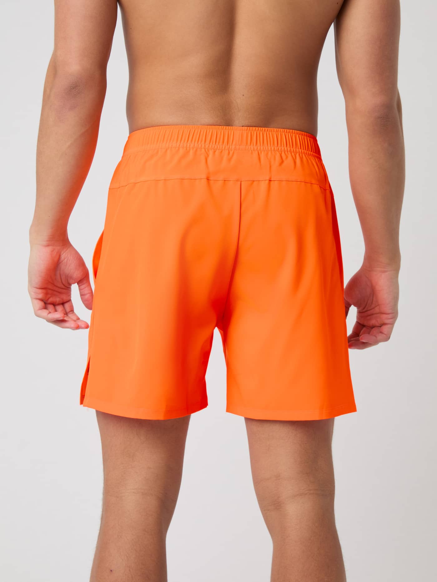 Back view of a model wearing Björn Borg Ace Racquet Shorts 7 Inch in Shocking Orange. - Image 2