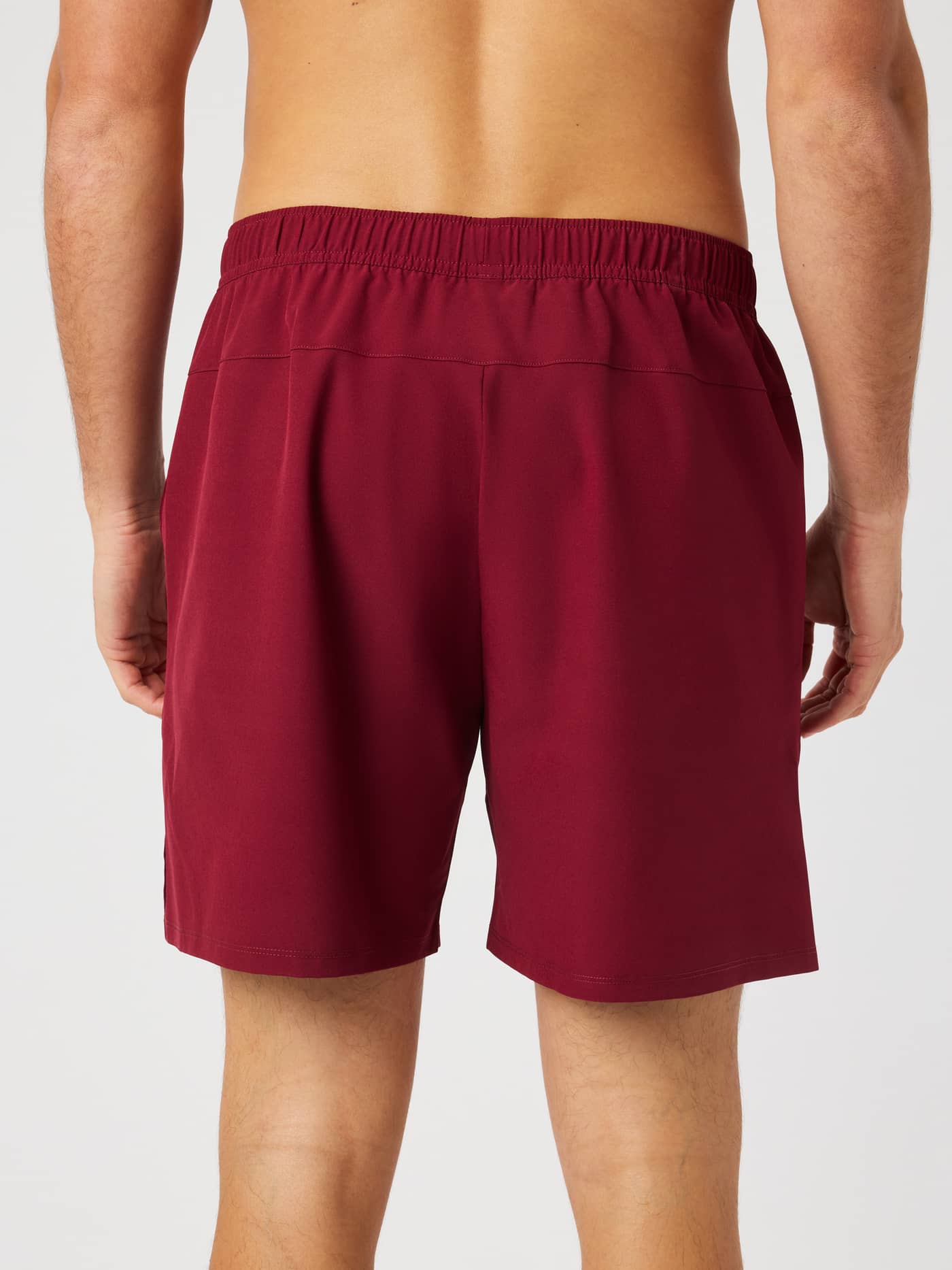 Back view of a model wearing the Ace Racquet Shorts 7 Inch in Cabernet (Red) for tennis and padel. - Image 2
