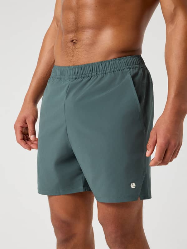Front view of the Björn Borg Ace Racquet Shorts 7 Inch in Urban Chic (Green), with a white tennis ball logo for performance.