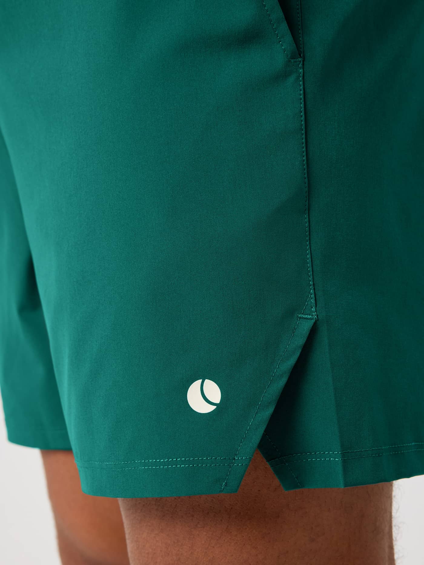 Gros plan latéral du Ace Racquet Shorts 7 Inch en Posy Green (Vert) avec fente latérale et logo balle de tennis blanc. - Image 4