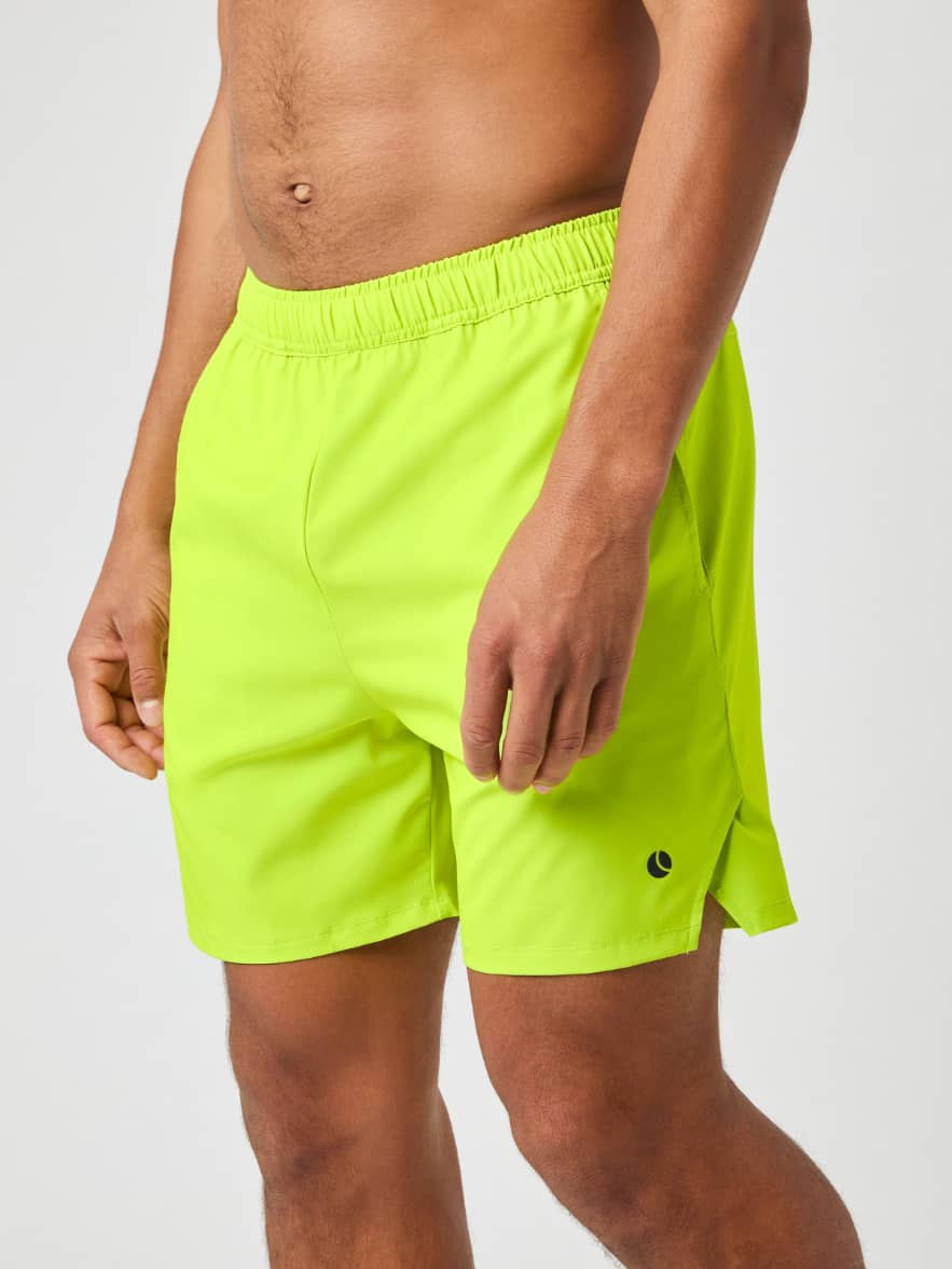 Model seen from the side wearing the Björn Borg Ace Racquet Shorts 7 Inch in a bright Acid Lime color. - Image 2