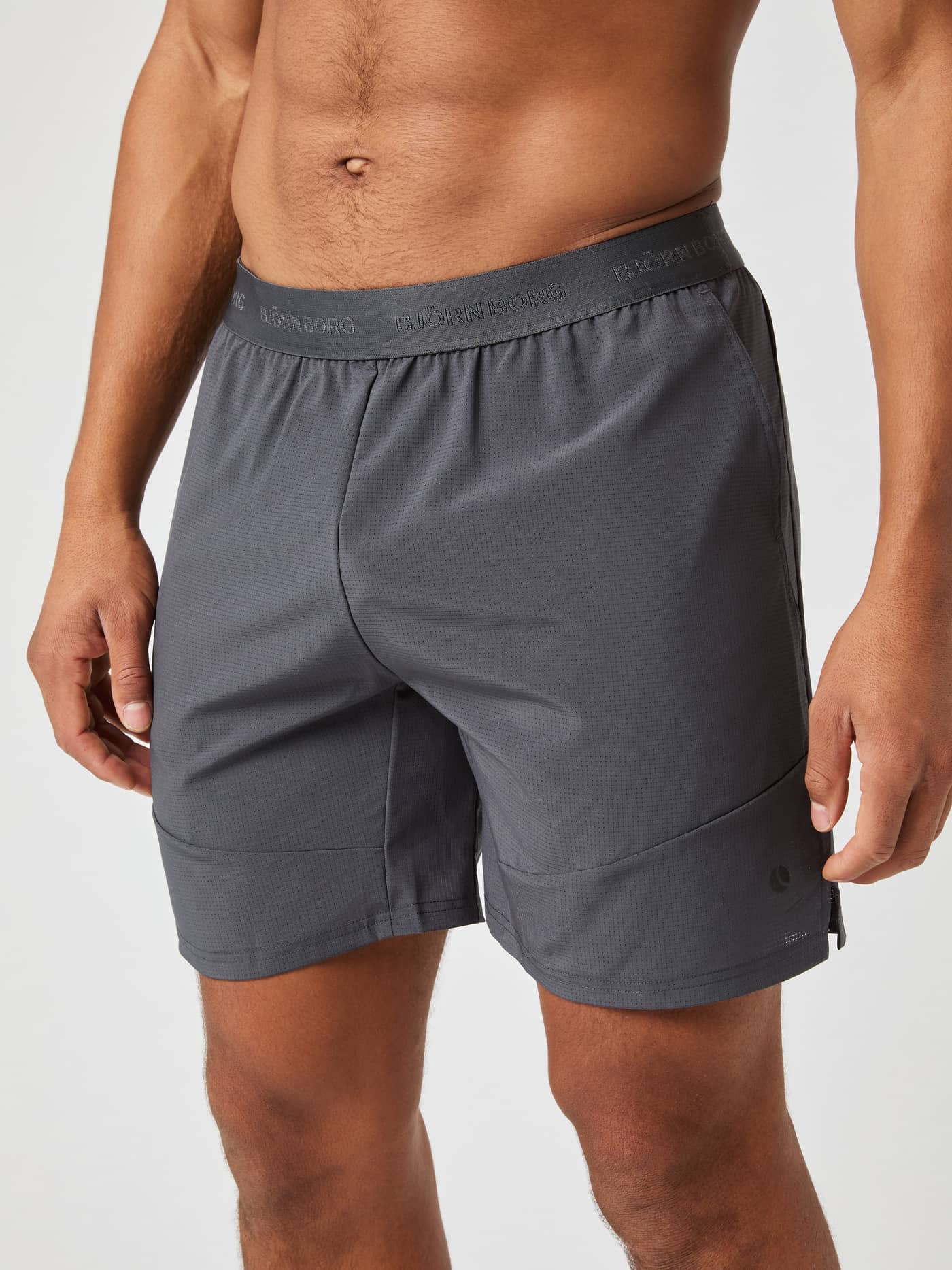 Front view of a man wearing the Björn Borg Ace Pro Shorts 7 Inch in Asphalt (Grey) with a tonal branded waistband for tennis. - Image 1