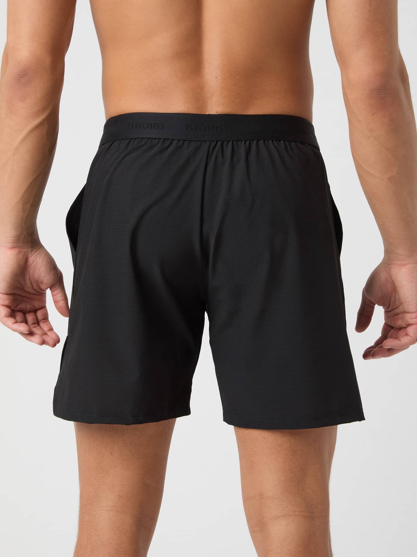 Back view of a man wearing the Ace Pro Shorts 7 Inch in Black Beauty (Black), providing performance and style for tennis. - Image 2