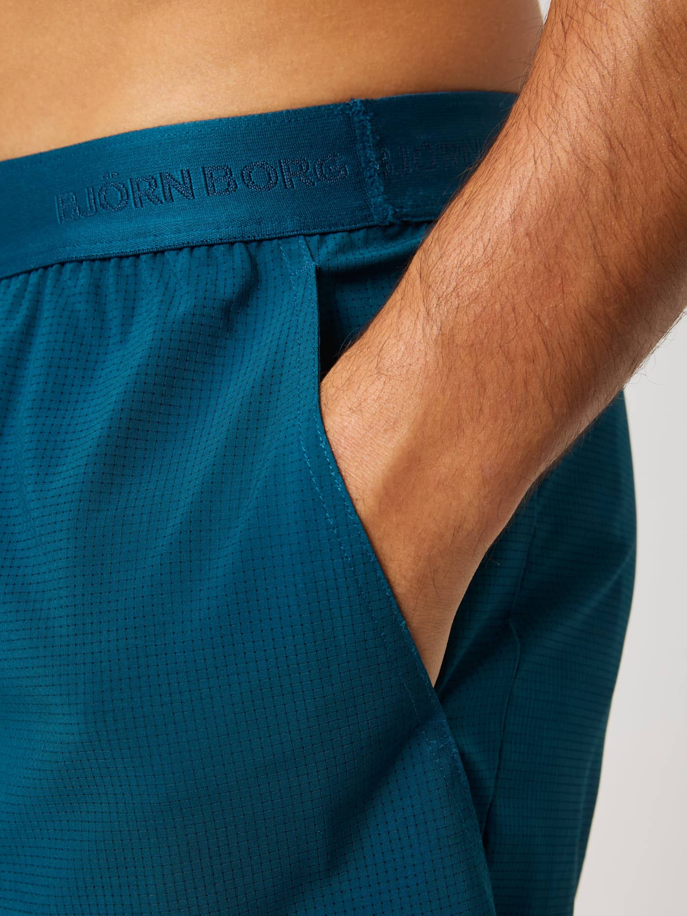 Close-up of Ace Pro Shorts 7 Inch in Reflecting Pond (Green) showing the branded waistband and side tennis ball pocket. - Image 5