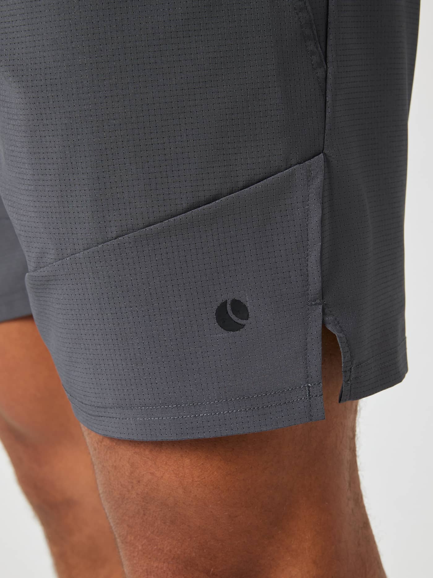 Detailed close-up of the men's Ace Pro Shorts 7 Inch in Asphalt (Grey) with a black logo and tennis ball pocket. - Image 4