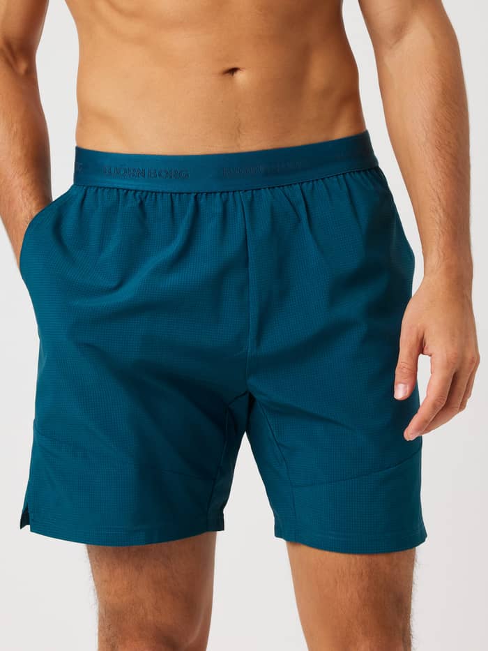 Front view of Ace Pro Shorts 7 Inch in Reflecting Pond (Green) with a tonal logo and side pockets for tennis.