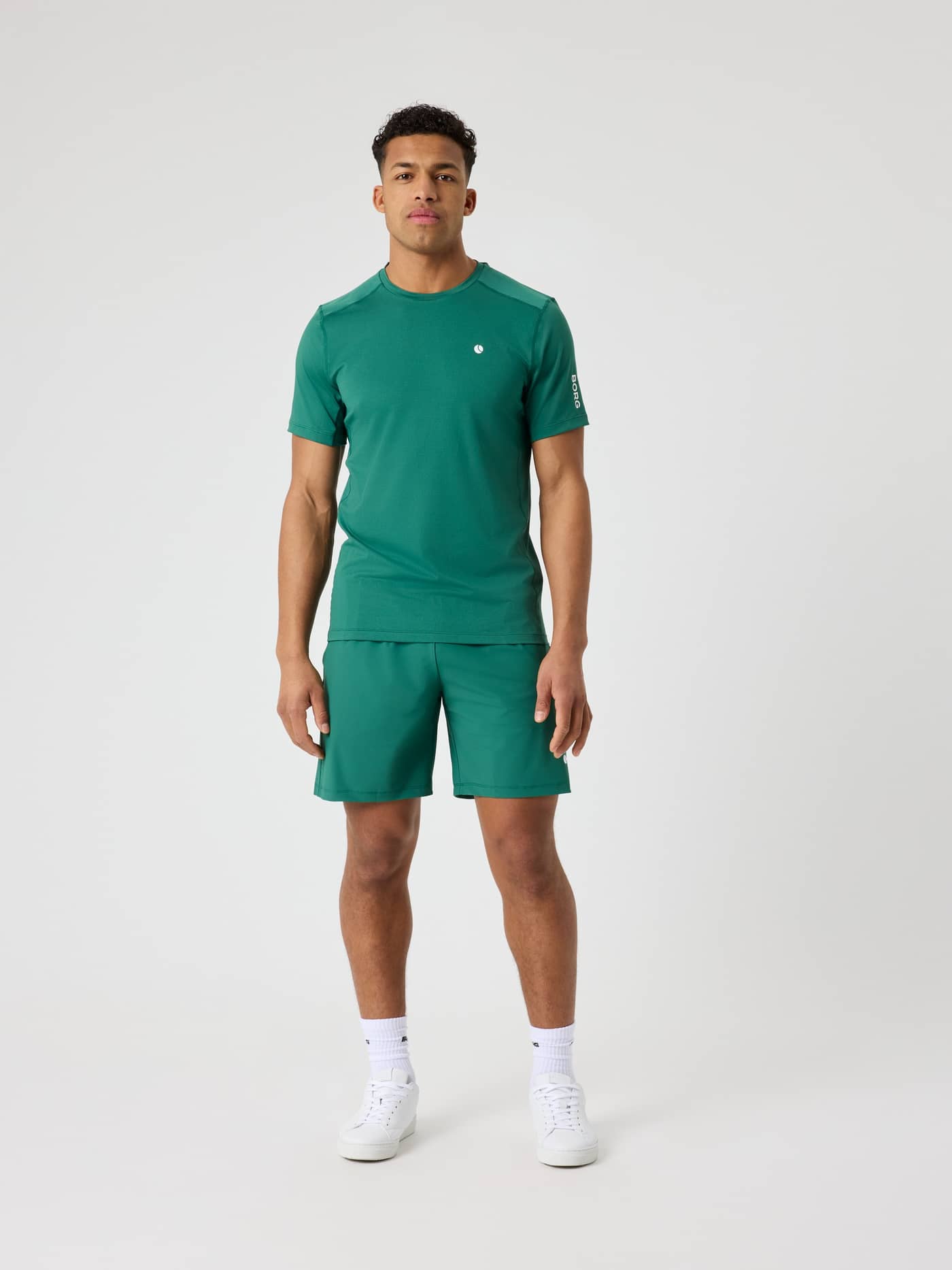 Front view of a man wearing the Björn Borg Ace Sports Shorts 8 Inch in Posy Green (Green) for tennis with a white logo. - Image 3