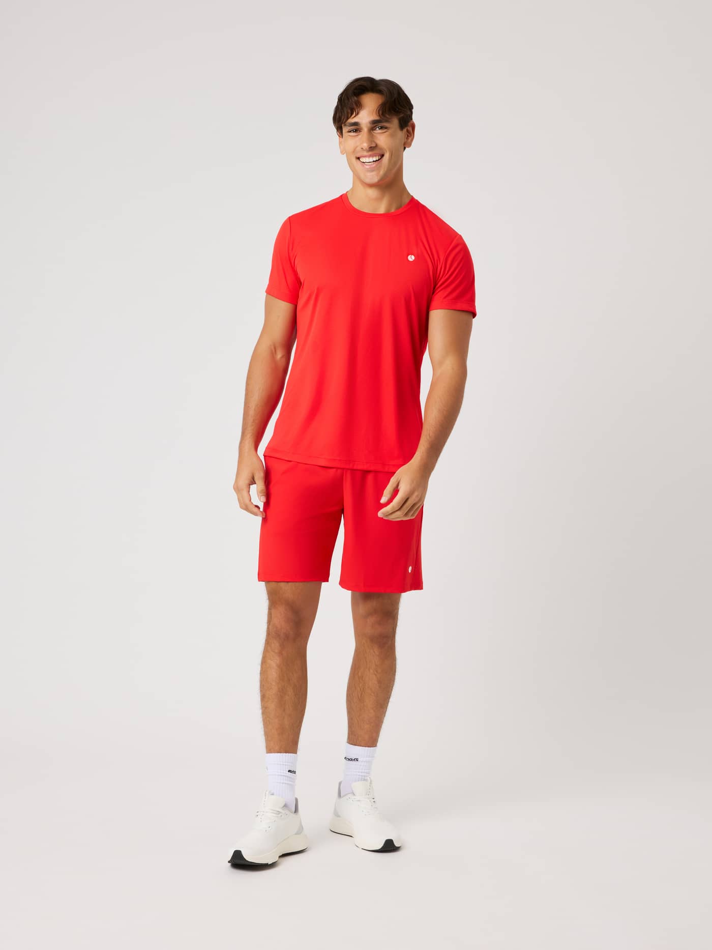 Vooraanzicht van een man in Ace Sports Shorts 8 Inch in Flame Scarlet (Rood) voor functionele beweging op de tennisbaan. - Image 3