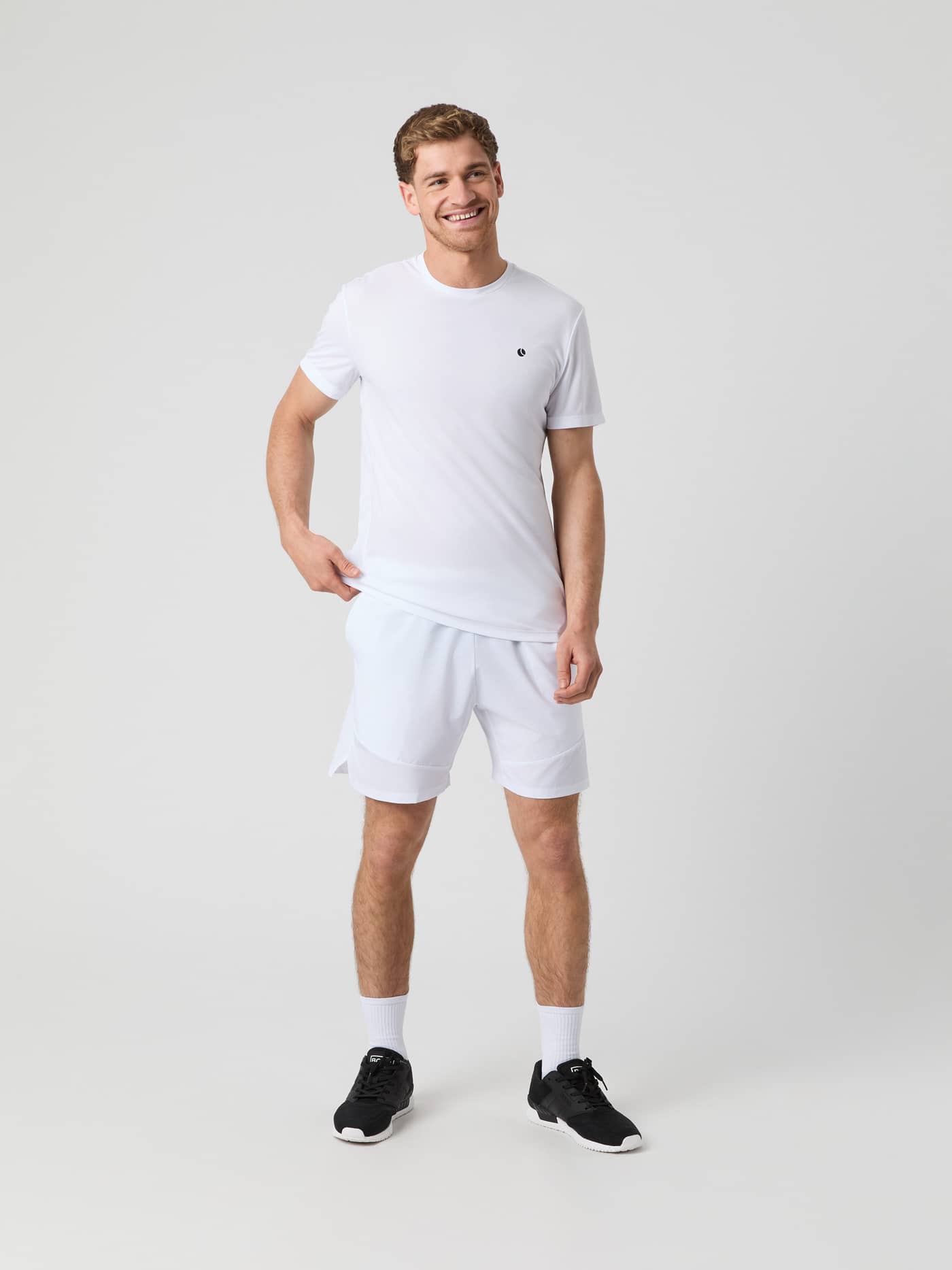 Front view of a man wearing the white Björn Borg Ace Sports Shorts, paired with a white t-shirt and black sneakers. - Image 2
