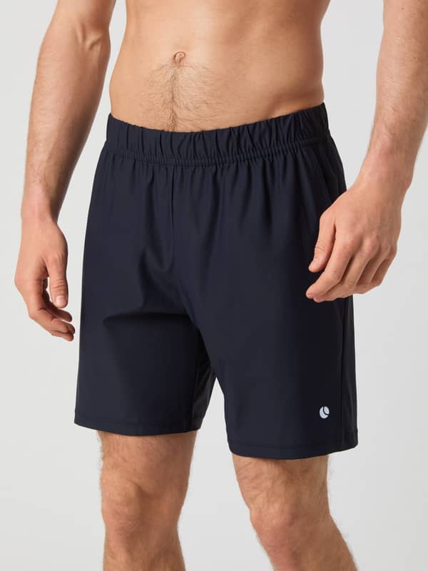Close-up front view of a man wearing the navy Björn Borg Ace Sports 8" Shorts, highlighting the elastic waistband and fit.