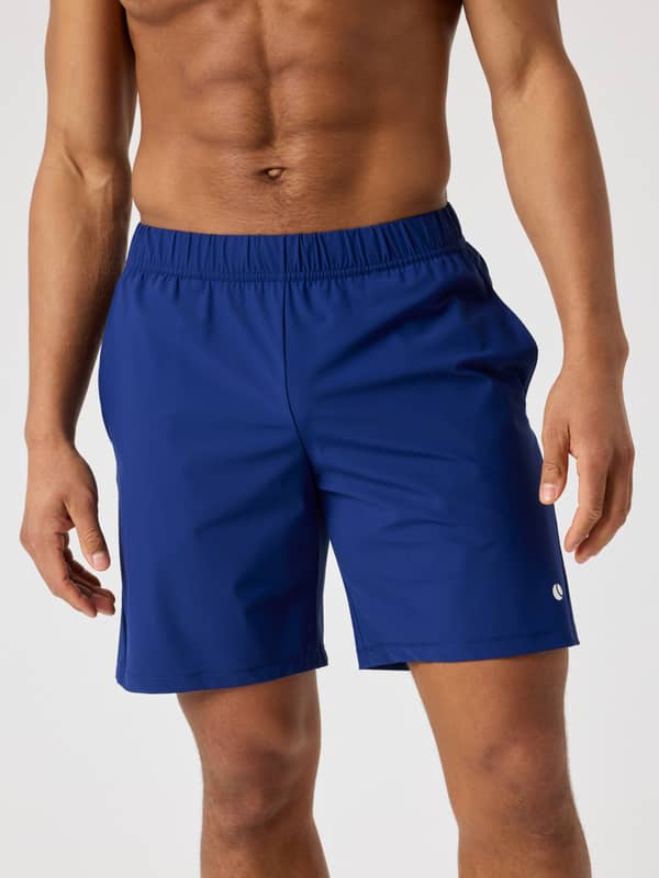 Front view of a man wearing the Blue Depths (Blue) Björn Borg Ace Sports Shorts 8 Inch with a white tennis logo.