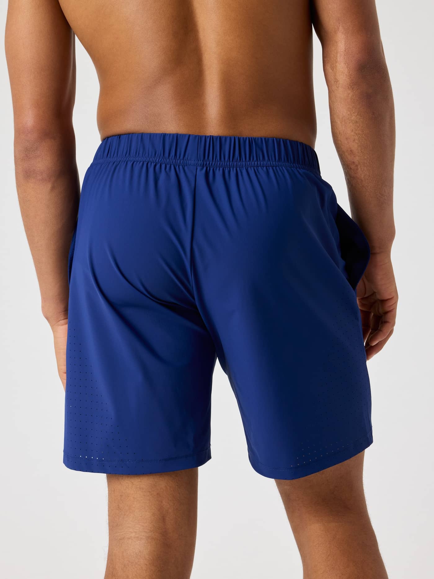 Ace Sports Shorts 8 Inch i Blue Depths (Blå) sett bakfra, med funksjonelle perforerte detaljer for tennis. - Image 2