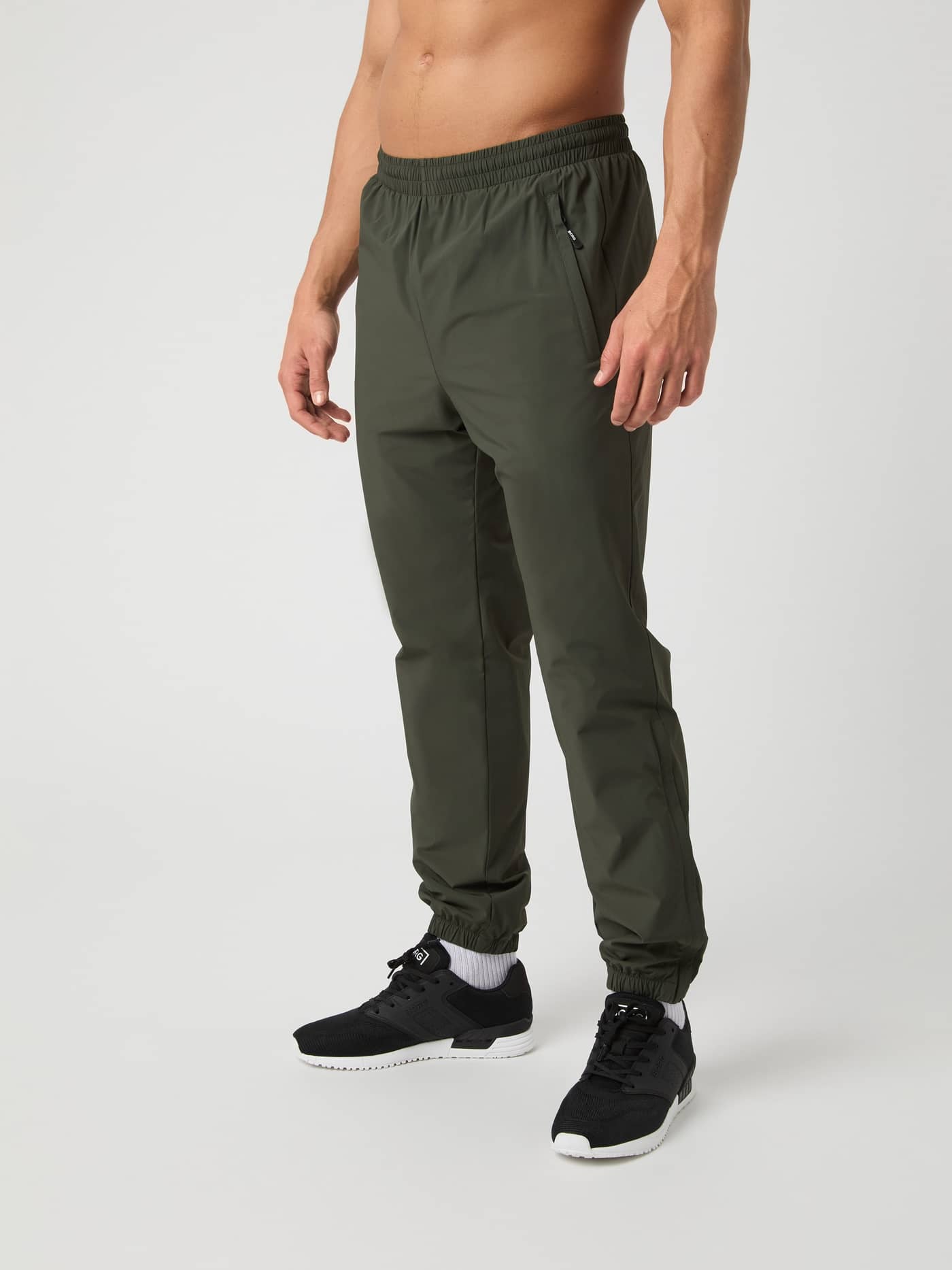 Ace Track Pants i Peat (Grønn) for menn sett fra siden forfra, designet for tennis og sportslig ytelse. - Image 2
