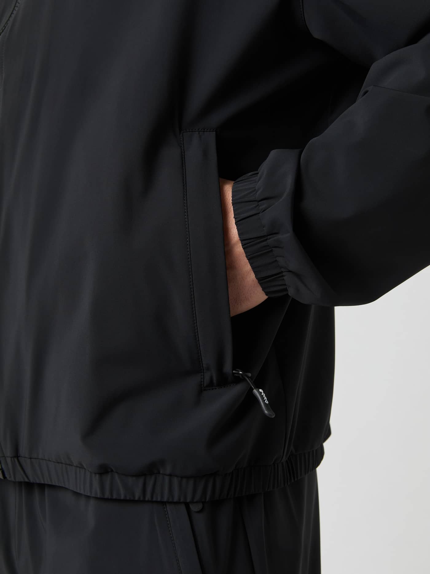 Nærbillede af Ace Track Jacket i Black Beauty (Sort) med lynlåslomme og elastisk manchet til tennis. - Image 4