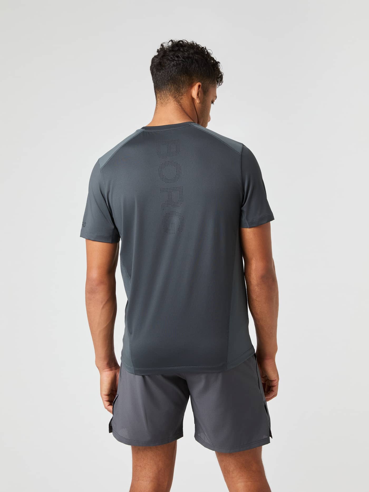 Rückansicht eines Mannes im Ace Mesh Panel T-Shirt in Asphalt (Grau) mit Mesh-Einsätzen und perforiertem Logo für Tennis. - Image 2