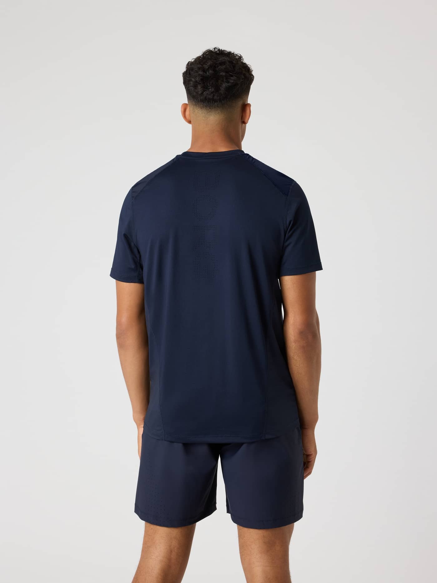 Vista posterior de la Ace Mesh Panel T-Shirt en Night sky (Marino) con malla transpirable y logo perforado para tenis. - Image 2
