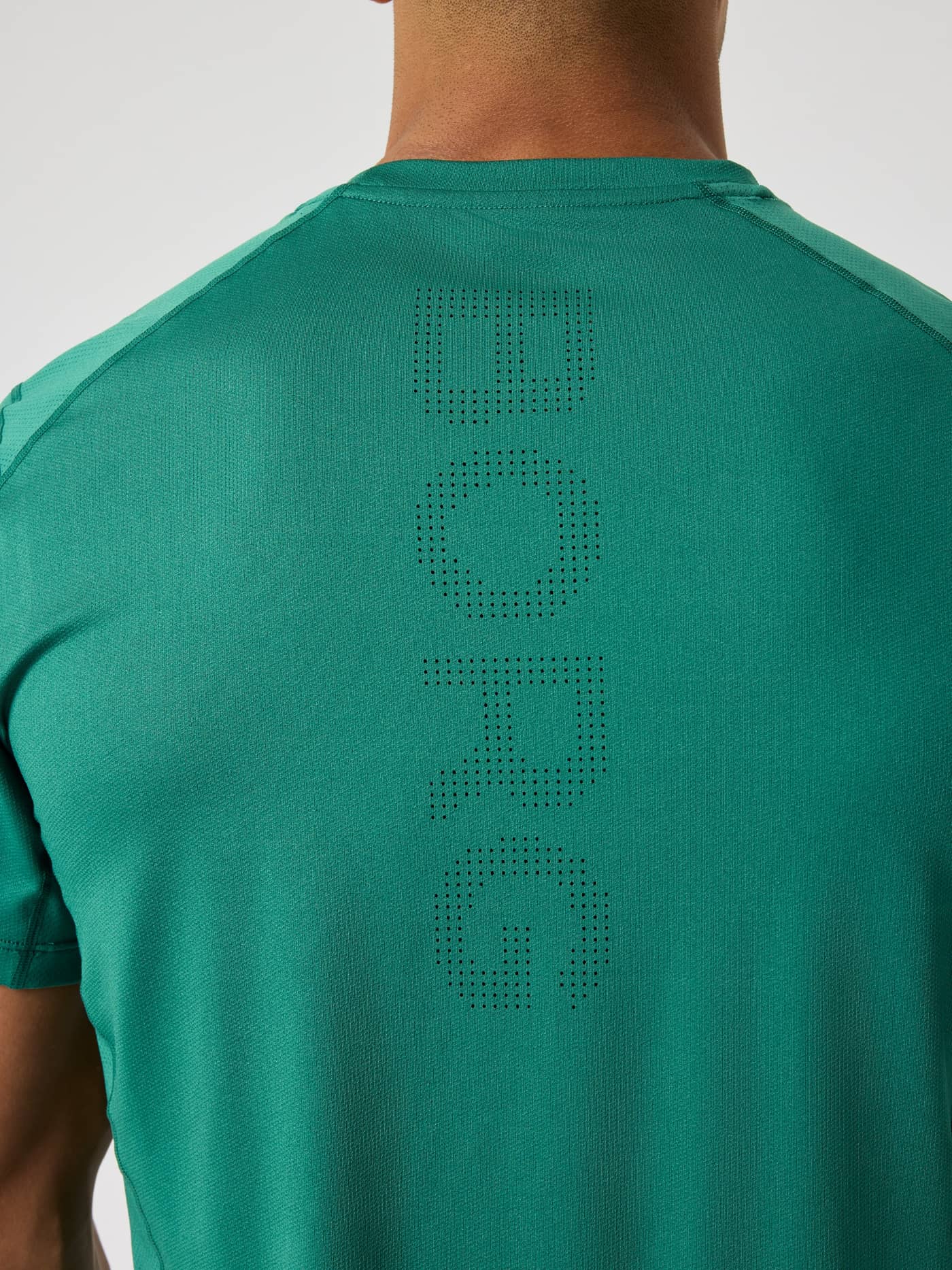 Back close-up of the Ace Mesh Panel T-Shirt in Posy Green (Green) featuring a perforated BORG logo for tennis. - Image 4