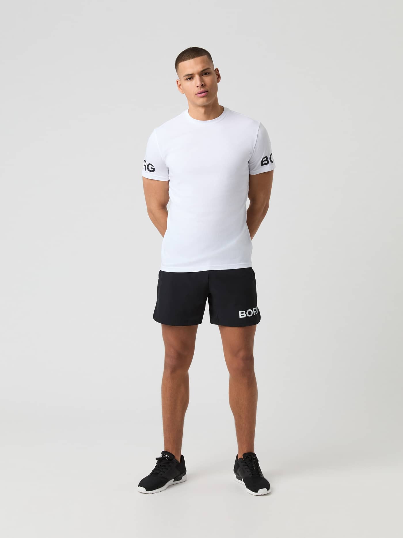 Front view of a man wearing the Björn Borg Ace Mesh Panel T-Shirt in Brilliant White (White) with black logos for tennis. - Image 3