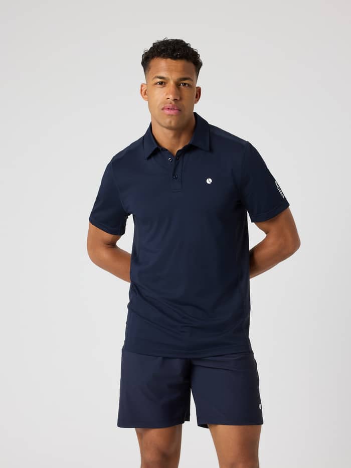 Front view of a man wearing the Björn Borg Ace Mesh Panel Polo Shirt in Night Sky (Navy) with a white tennis logo.