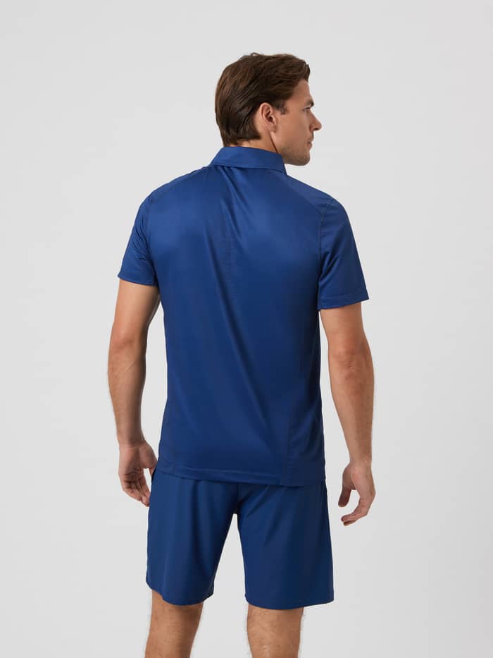 Back view of a man in the Ace Mesh Panel Polo Shirt in Estate Blue (Blue) for stylish and functional tennis performance. - Image 3
