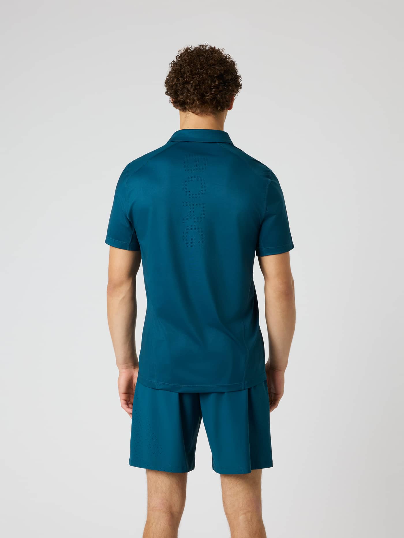 Back view of the Ace Mesh Panel Polo Shirt in Reflecting Pond (Green), featuring a perforated logo for tennis performance. - Image 2