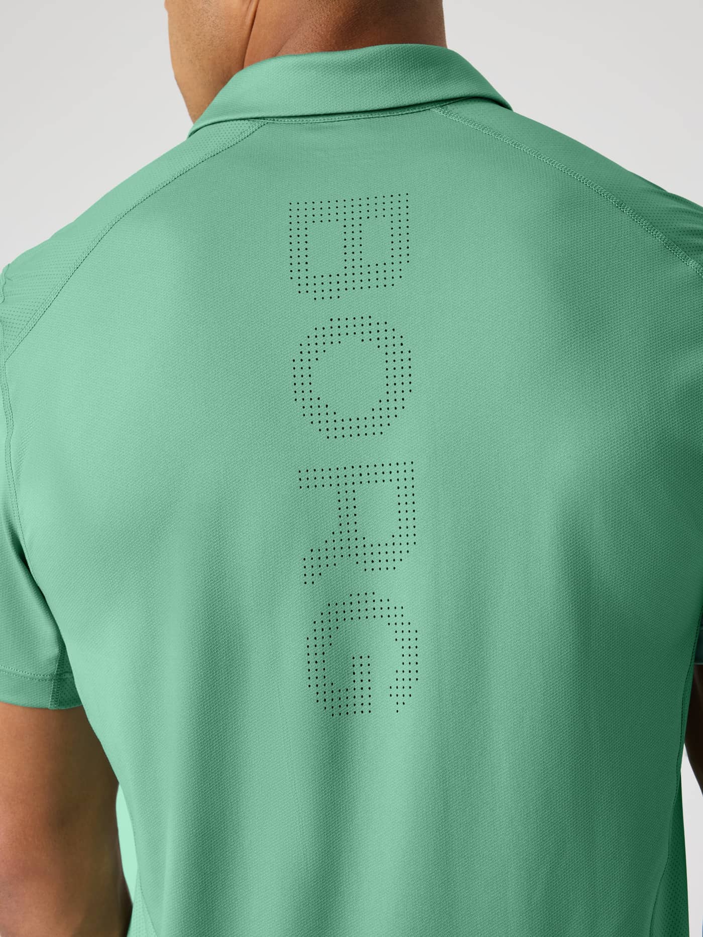Close-up back view of the Ace Mesh Panel Polo Shirt in Malachite Green (Green) with a perforated BORG logo for tennis. - Image 4