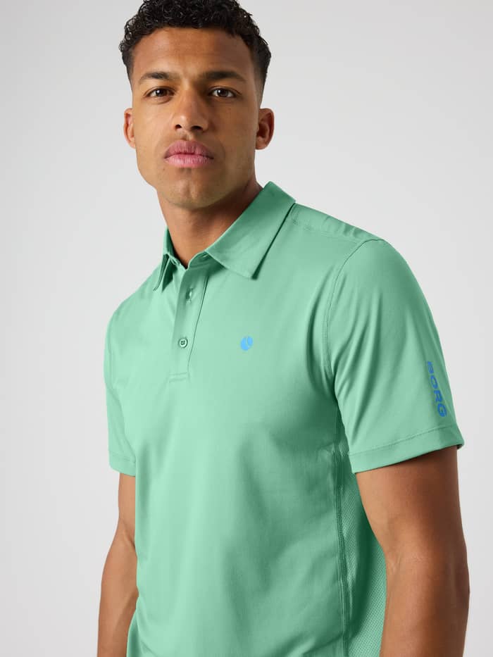 Front view of a man in the Malachite Green (Green) Ace Mesh Panel Polo Shirt with mesh details and a blue tennis ball logo. - Image 5