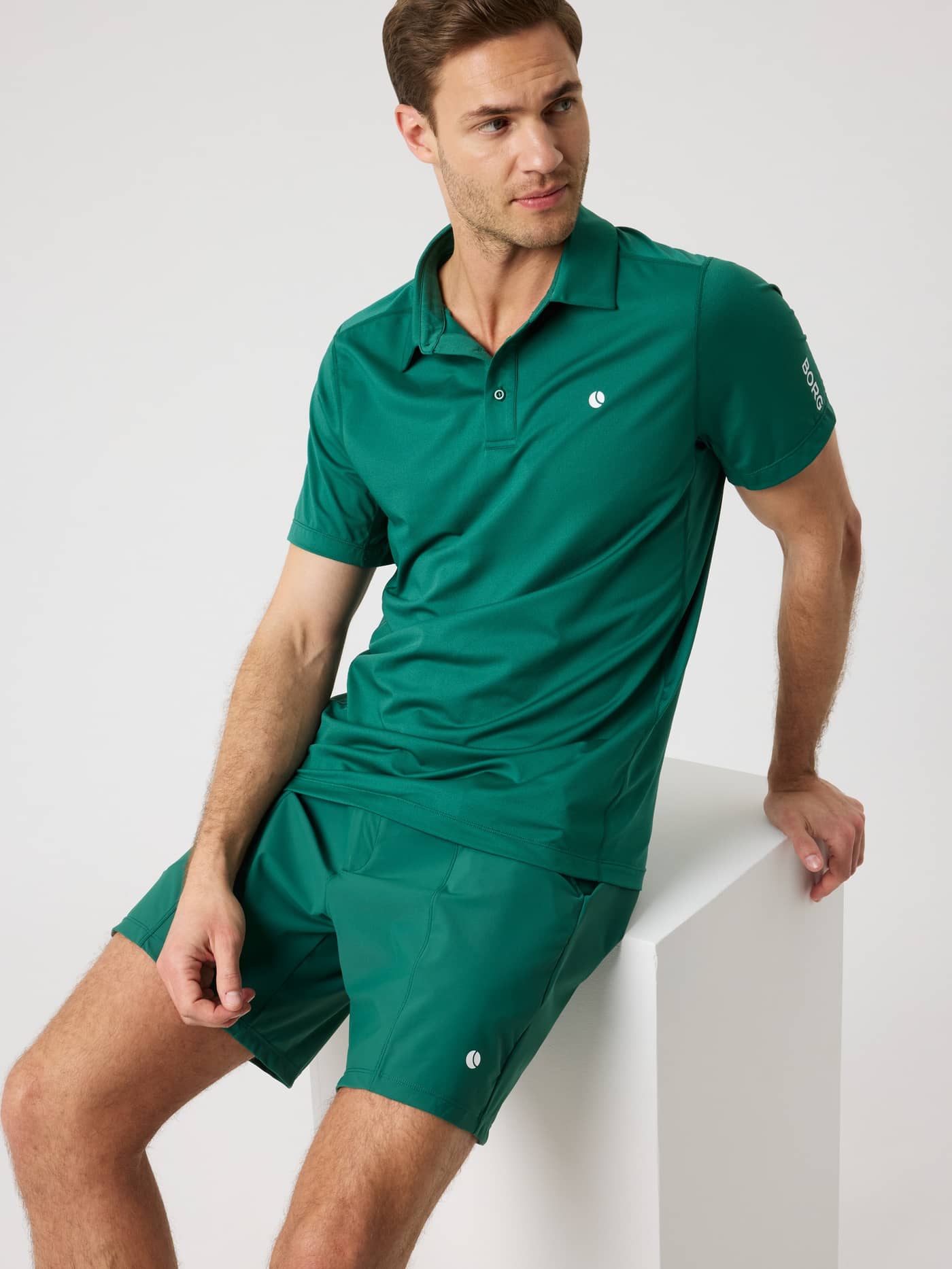 Ace Mesh Panel Polo Shirt in Posy Green (Grün) an einem sitzenden Mann, ideal für Tennis dank Mesh-Einsätzen. - Image 7