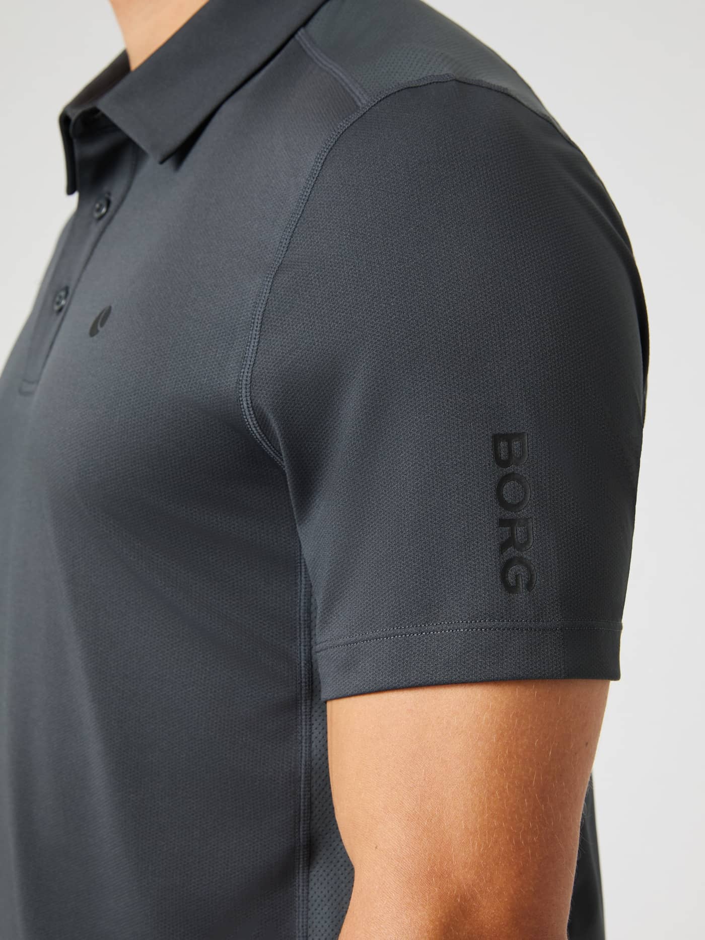 Detailed close-up of the Ace Mesh Panel Polo Shirt in Asphalt (Grey), a functional tennis polo with a stylish BORG logo. - Image 5