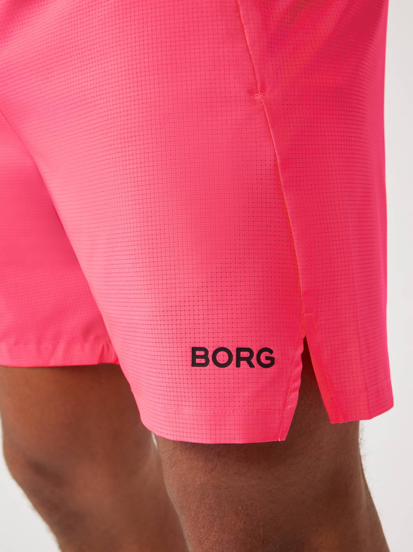 Närbild på Borg Zip Shorts 7 Inch i Diva Pink (Rosa) för träning med en svart Borg-logotyp och sidoslits. - Image 5