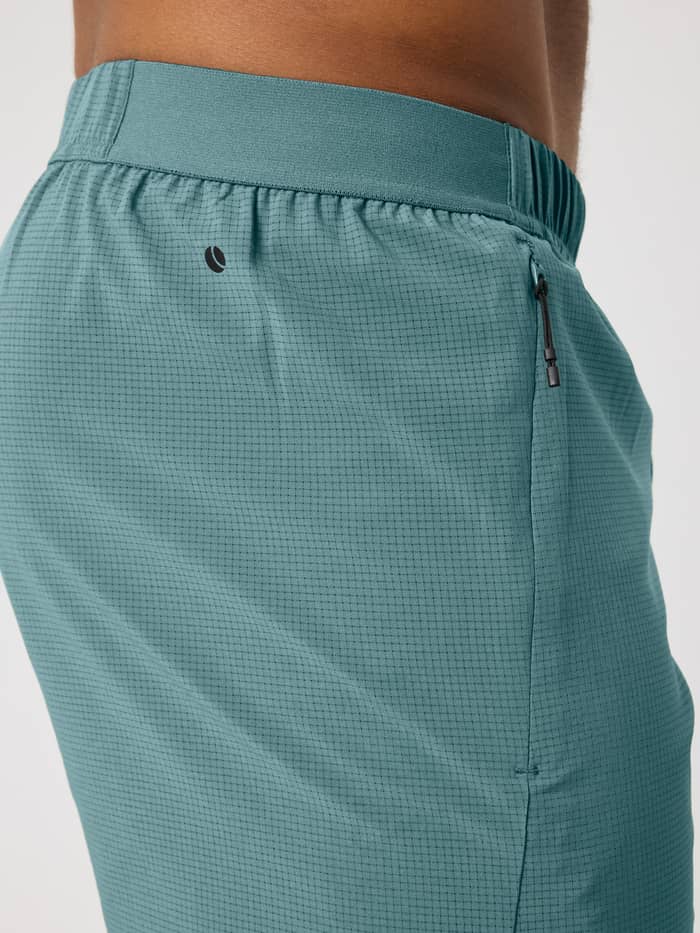 Borg Zip Shorts 7 Inch i Balsam Green (Grøn) set fra siden med perforeret vævning og et sort tennislogo. - Image 5