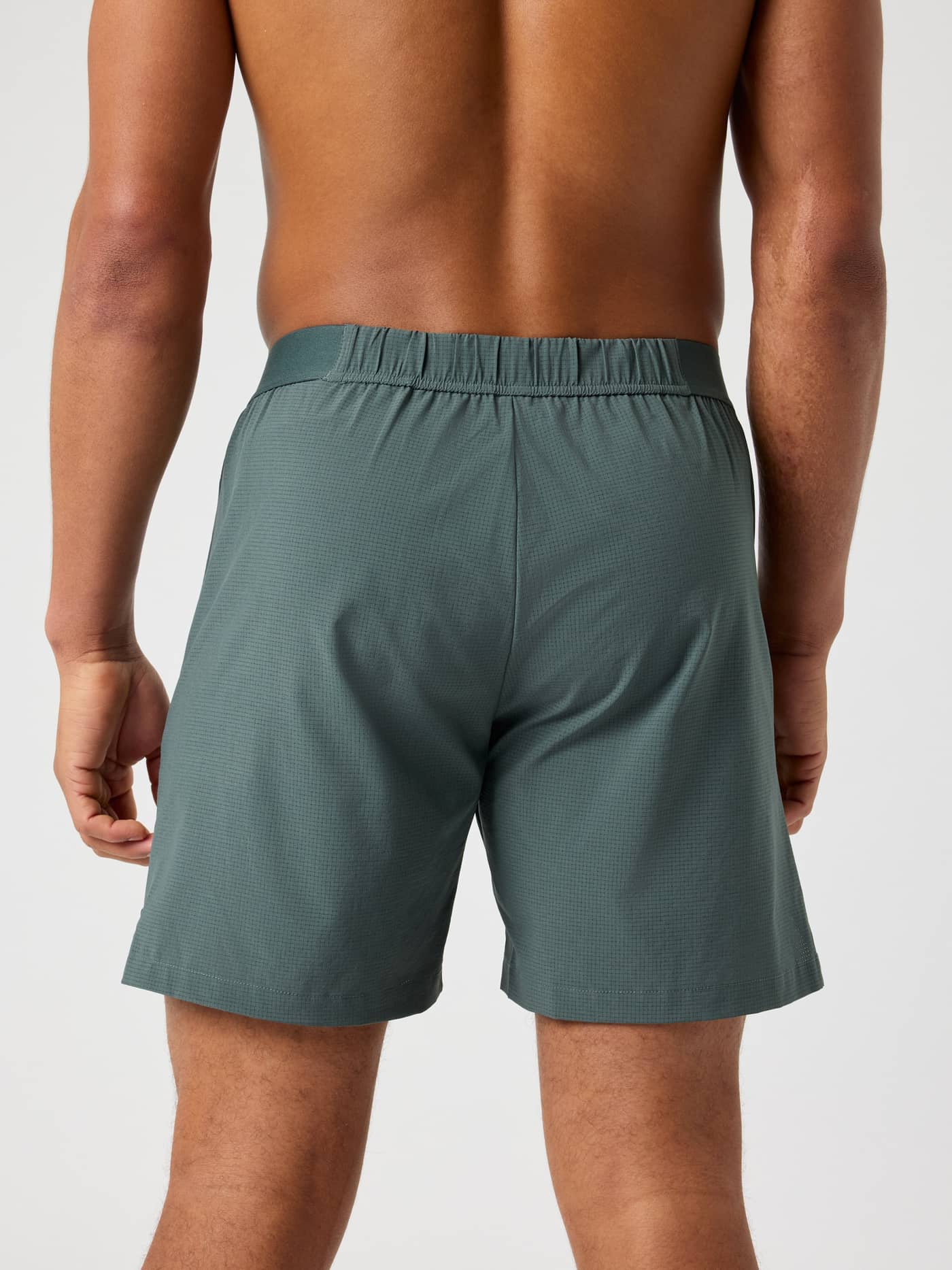 Back view of a man wearing the Urban Chic (Green) Borg Zip Shorts 7 Inch for training, featuring a dual elastic waistband. - Image 2