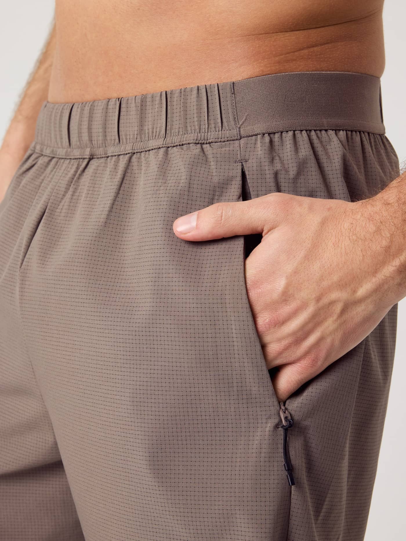 Close-up van de Falcon (Bruin) Borg Zip Shorts 7 Inch voor training met technisch jacquard-weefsel en ritszak. - Image 5