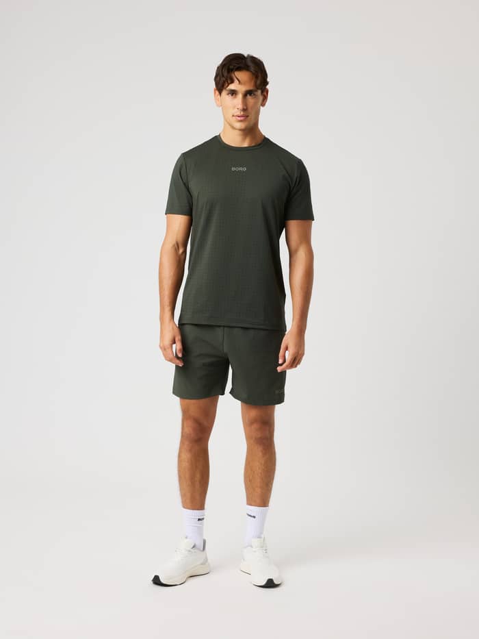 Ganzkörper-Vorderansicht eines Mannes in Borg Zip Shorts 7 Inch in Rosin (Grün) für Training und Gym-Sessions. - Image 3