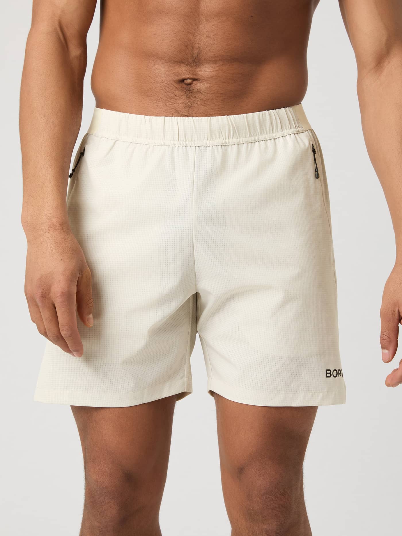 Front view of a man wearing the Björn Borg Zip 7" Shorts in Birch. - Image 1